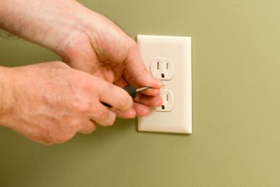 technician installing a tamper resistant outlet