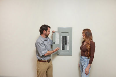 Tech showing electrical panel to customer