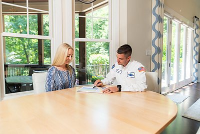 Technician and customer sitting at table reviewing options