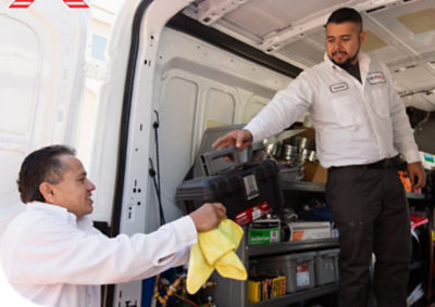 Tech handing tools out of the back of a van