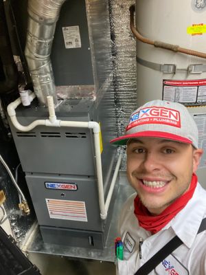 A NexGen tech taking a selfi in front of an HVAC system