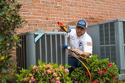 Tech testing the freon in a condenser