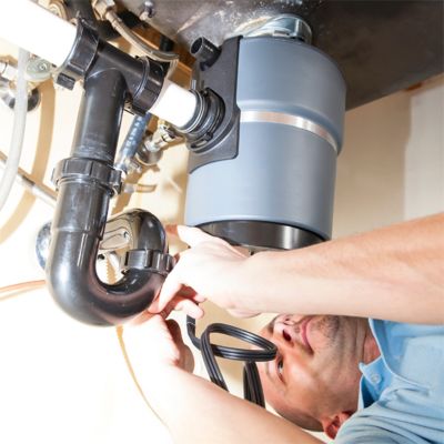 Tech under sink servicing a garbage disposal