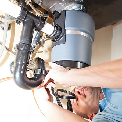 Tech under sink servicing a garbage disposal