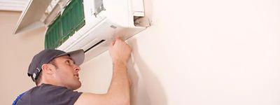 A technician working on an ductless HVAC unit