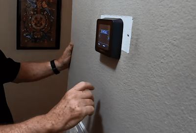 Technician adjusting thermostat