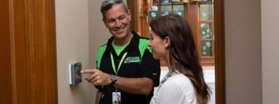 Technician instructing homeowner on themostat use - Thomas & Galbraith Heating, Cooling, & Plumbing