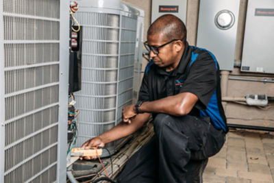 Coolray technician working on an HVAC system in a Birmingham, AL home