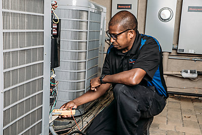 Coolray technician working on an HVAC system in a Birmingham, AL home