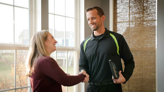 technician homeowner handshake indoors