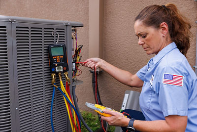 Technician testing or repairing a heat pump unit