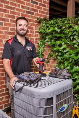 Ragsdale AC Repair tech standing by an air conditioning unit