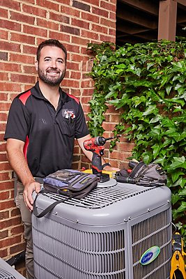 Ragsdale AC Repair tech standing by an air conditioning unit