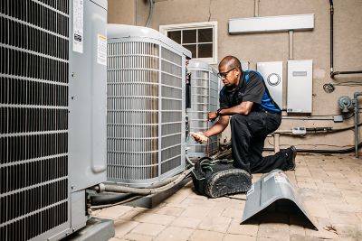 Coolray technician inspecting air conditioning unit