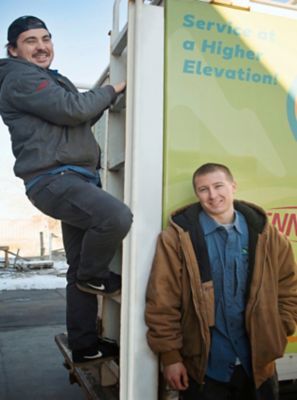 Two technicians standing outside a repair truck