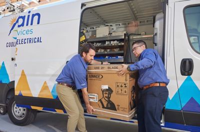 techs removing a new heat pump from work van