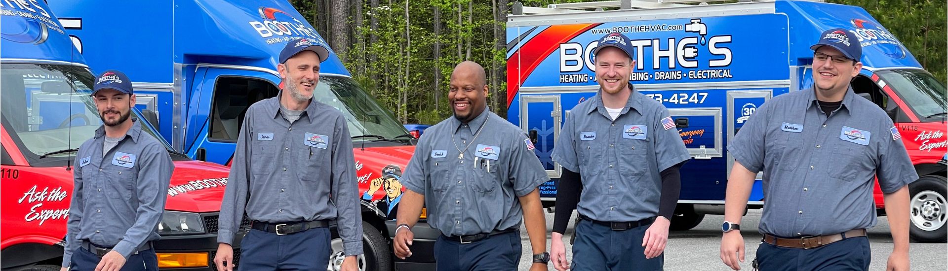 5 techs walking in front of service trucks 