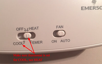 White thermostat with arrow pointing at cool setting