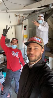 Three NexGen technicians taking a selfie in front of a water heater