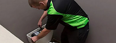 Plumber repairing a toilet - Thomas & Galbraith Heating, Cooling, & Plumbing