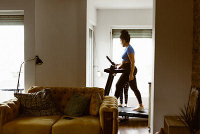 woman walking on treadmill in her home