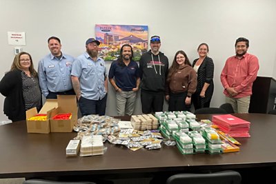Parker & Sons employees gathered around table with collected community supplies 