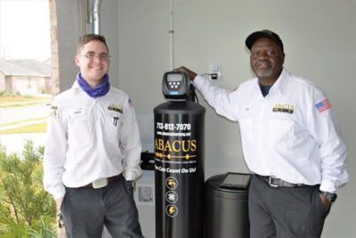 two technicians standing with black water filtration system