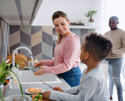 Woman and child using kitchen sink