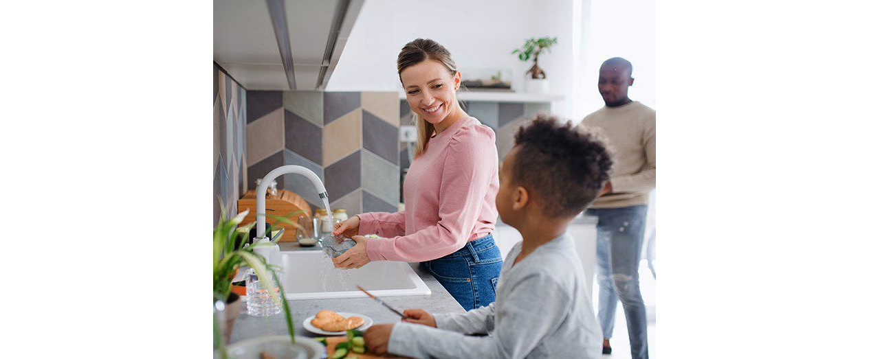 Woman and child using kitchen sink