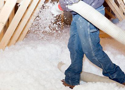 Person walking in an attic with insulation 