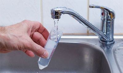 Filling a test tube with water.