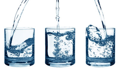 three water glasses with water being poured into them