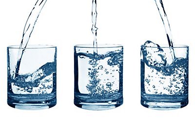 three water glasses with water being poured into them