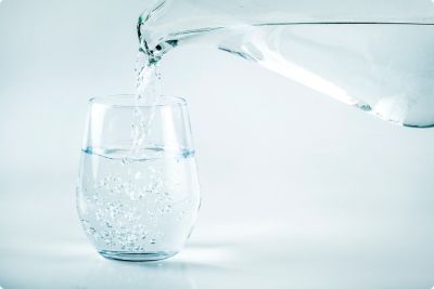 Pitcher pouring water into a clear water glass