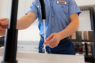 technician at kitchen sink testing the water quality
