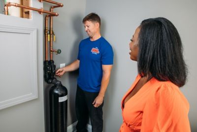 Plumber showing a customer a new water softener installed in their Atlanta area home