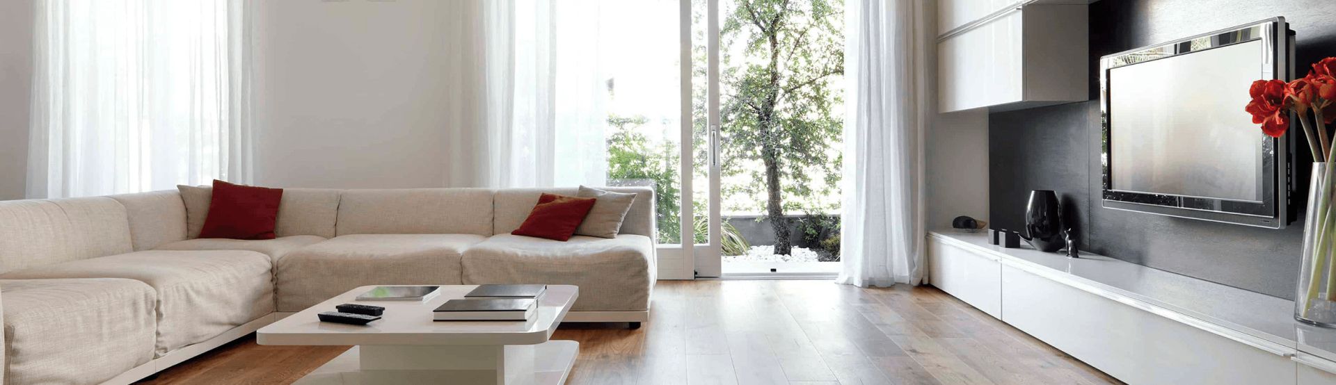 A living room with white furniture and a tv.