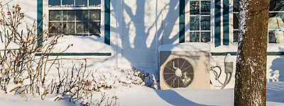 Heat pump outside a home in winter - Thomas & Galbraith Heating, Cooling, & Plumbing