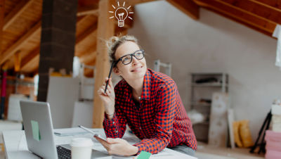 Woman looking up thinking while smiling with lightbulb over head