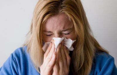 woman-sneezing-into-tissue-with-allergies