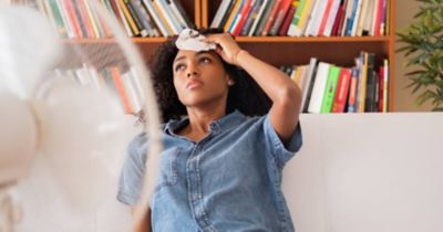 Woman wiping forehead because of heat