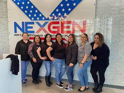 7 women standing in front of NexGen sign