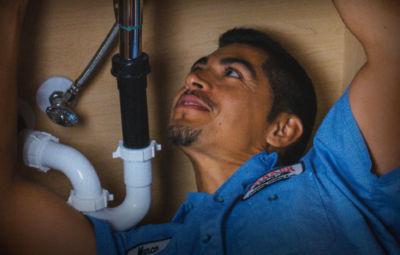 A technician working under a sink