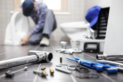 Floor view of plumber fixing toilet and tools 