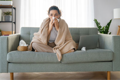 Ill upset girl is holding paper tissue and blowing nose. Virus symptom concept.