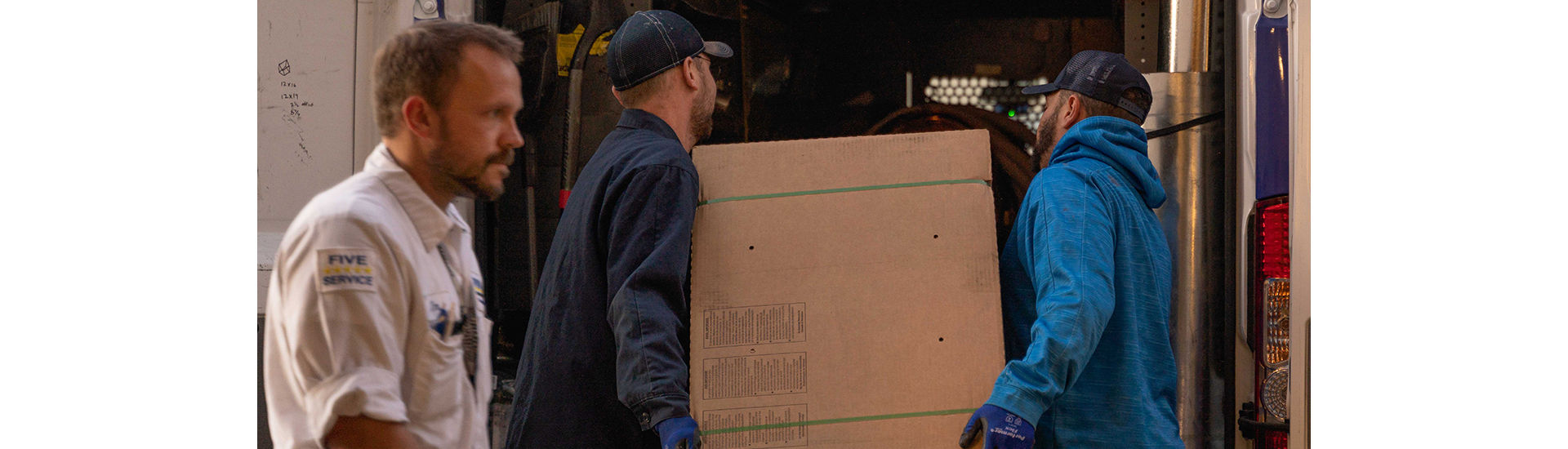 Plumbline employees loading box into truck