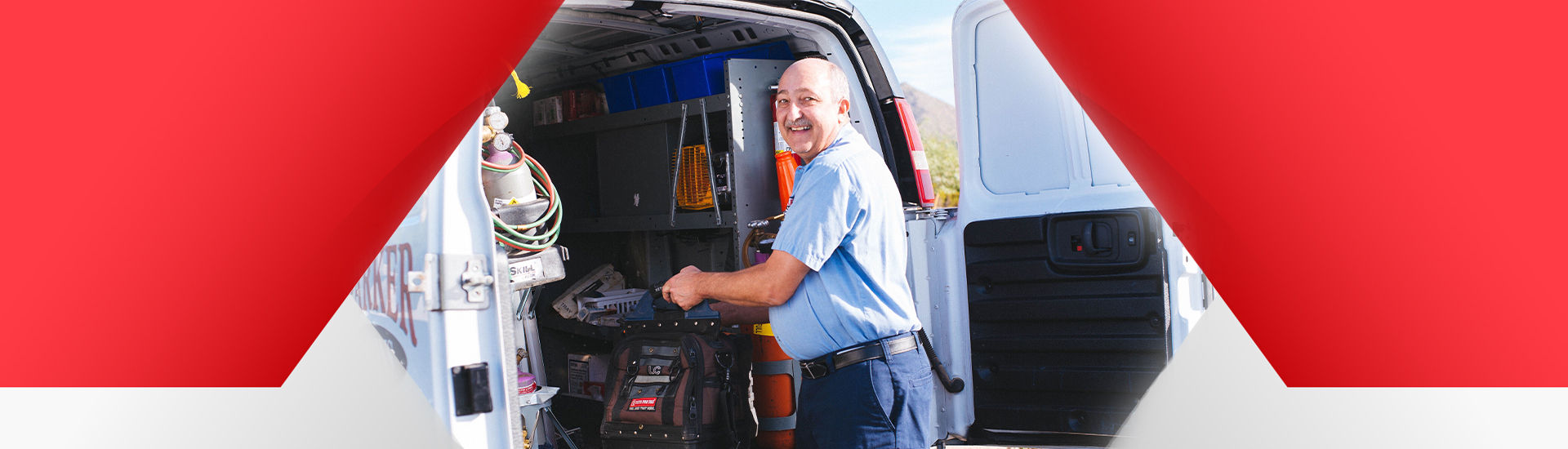 Technician smiling in front of his van