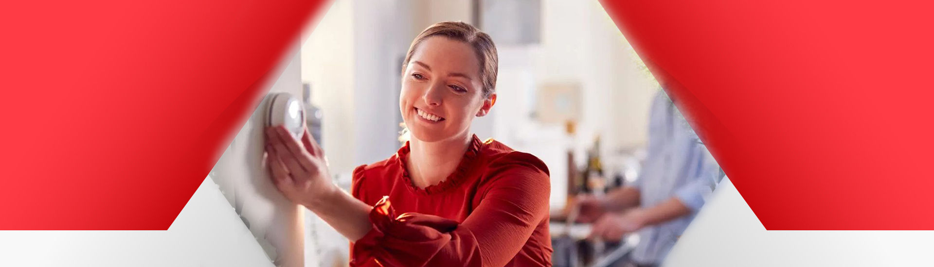 Woman setting home thermostat to perfect temperature 