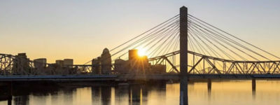 a bridge over water with a city in the background