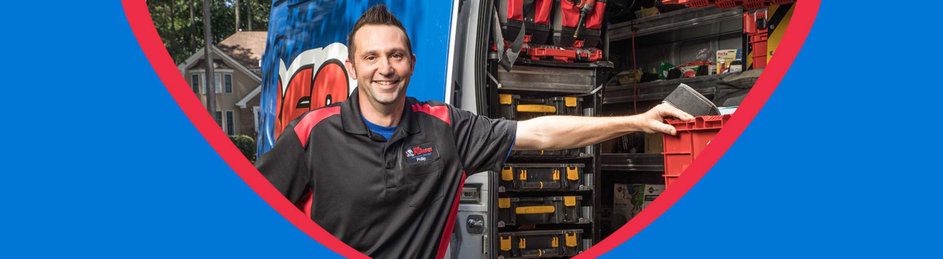 A plumber standing in front of a service vehicle